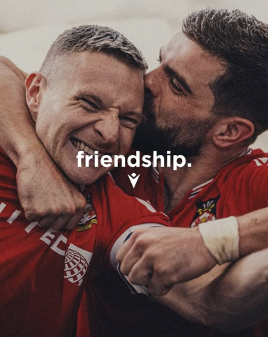 Zwei Männer umarmen sich fröhlich und zeigen eine enge Freundschaft.